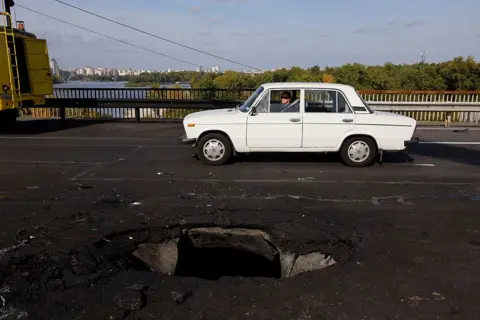 Kyiv bridge hit in further Russian drone attack as German chancellor makes surprise visit